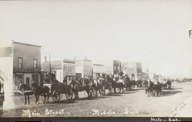 Main Street with a line of horse-drawn wagons